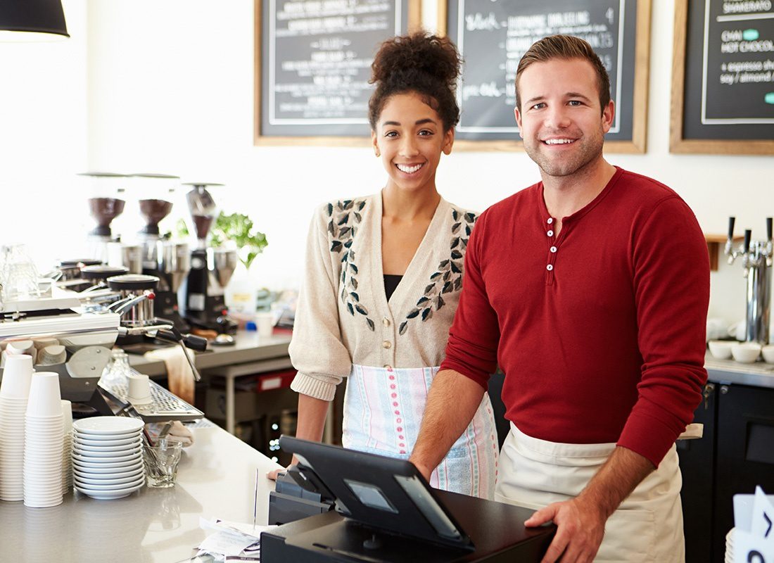 Business Insurance - Coffee Shop Owners Stand Together Smiling