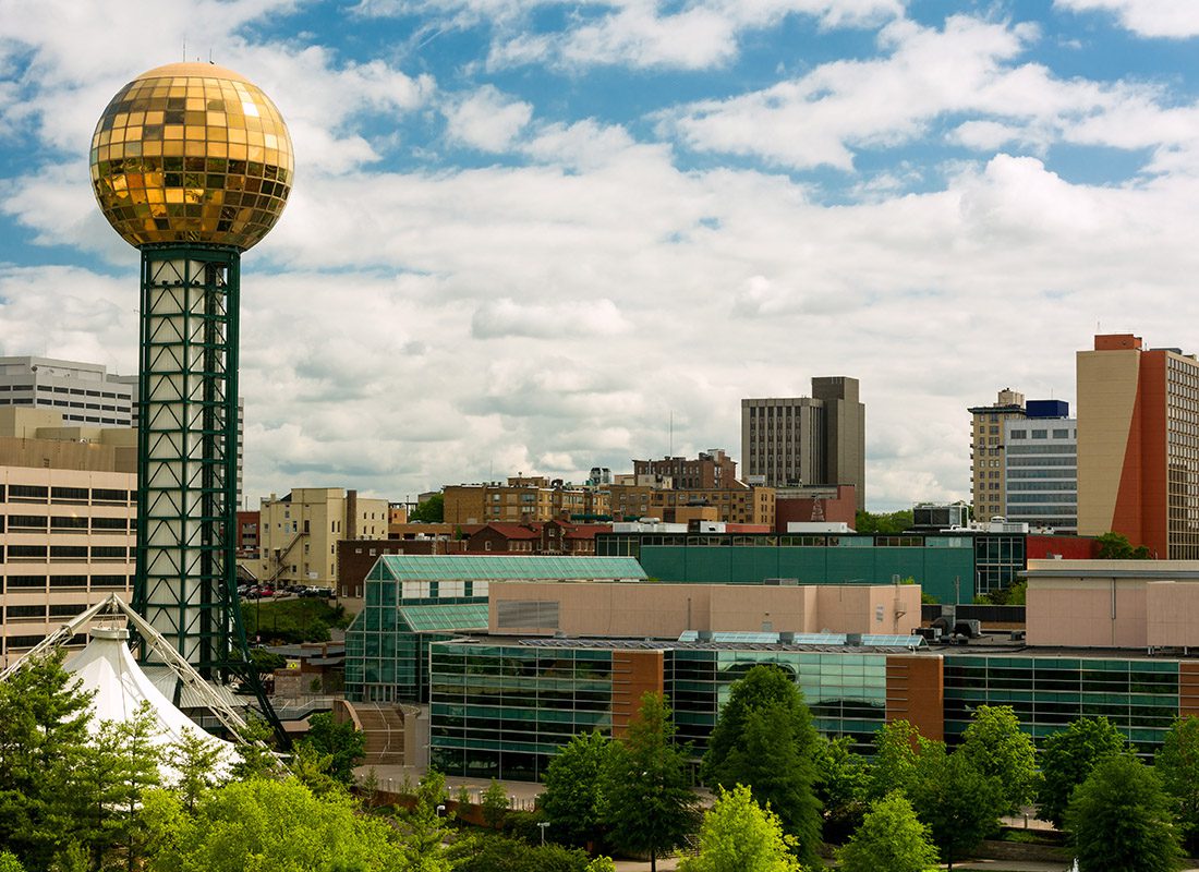 Insurance Solutions - Aerial View of Knoxville, Tennessee Displaying Buildings, Trees, and a Green Tower With a Golden Orb at the Top of it on a Sunny Day