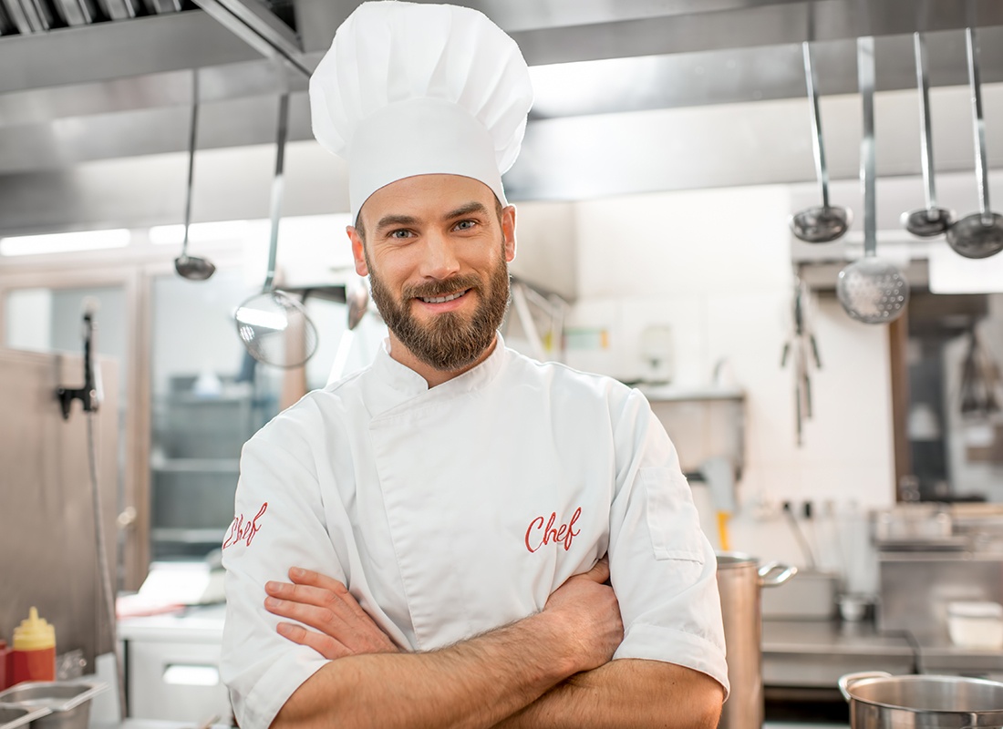 Insurance by Industry - Friendly Chef Crossing His Arms in a Kitchen